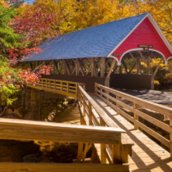 Red covered bridge in Fanconia New Hampshire during Fall season